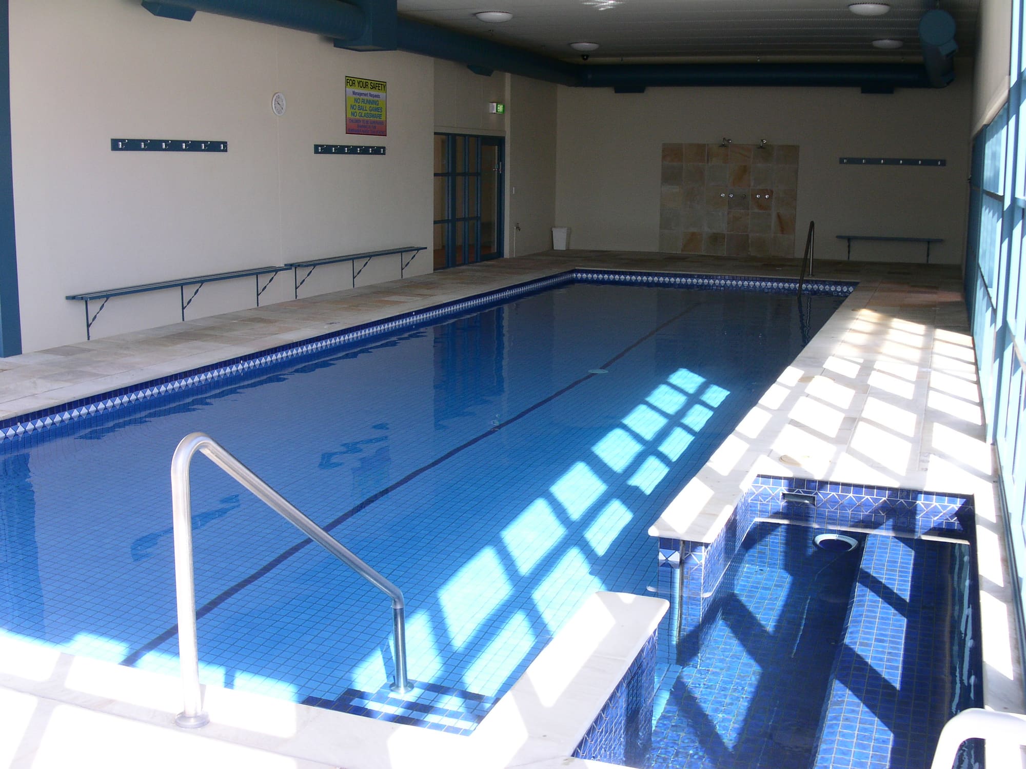 Indoor heated lap pool with a handrail and steps