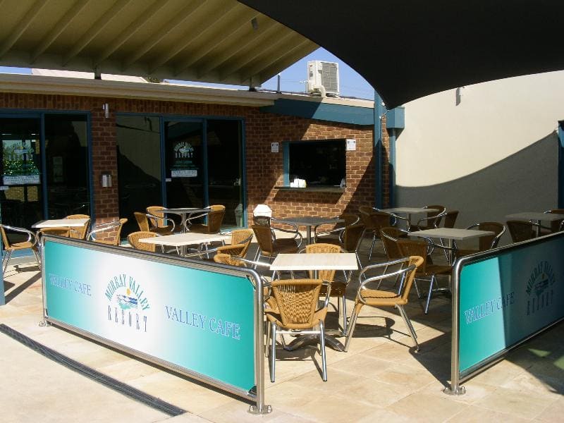 Alfresco cafe seating under a shade sail with Murray Valley Resort banners