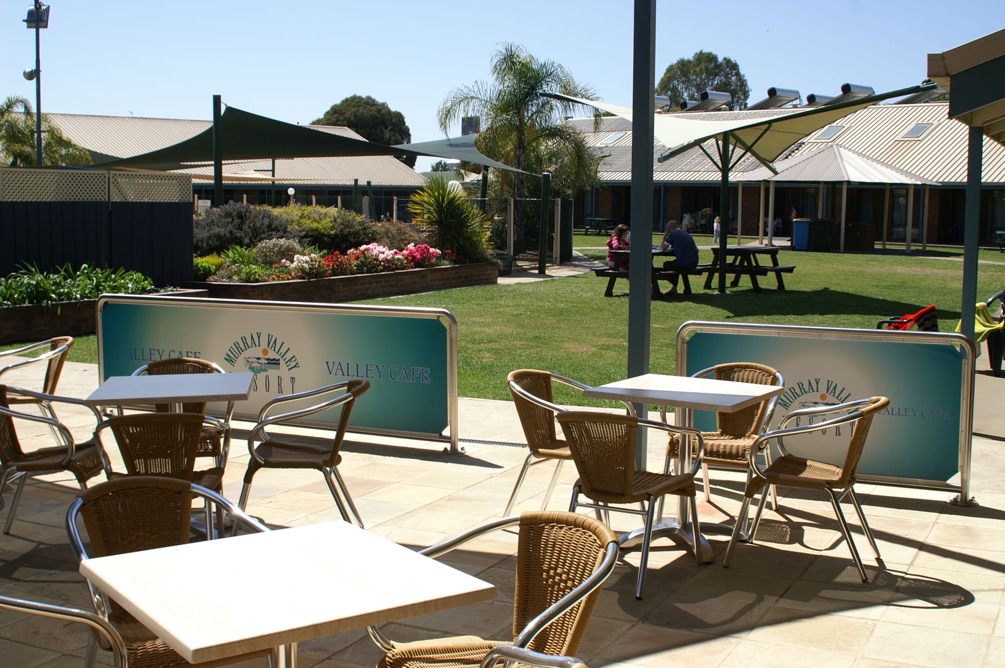 Cafe courtyard with tables and chairs looking out over the resort grounds