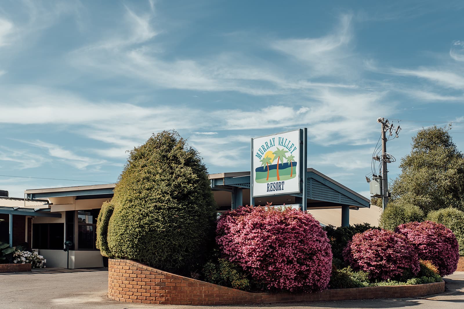 Murray Valley Resort sign at the entrance, above pink azaleas