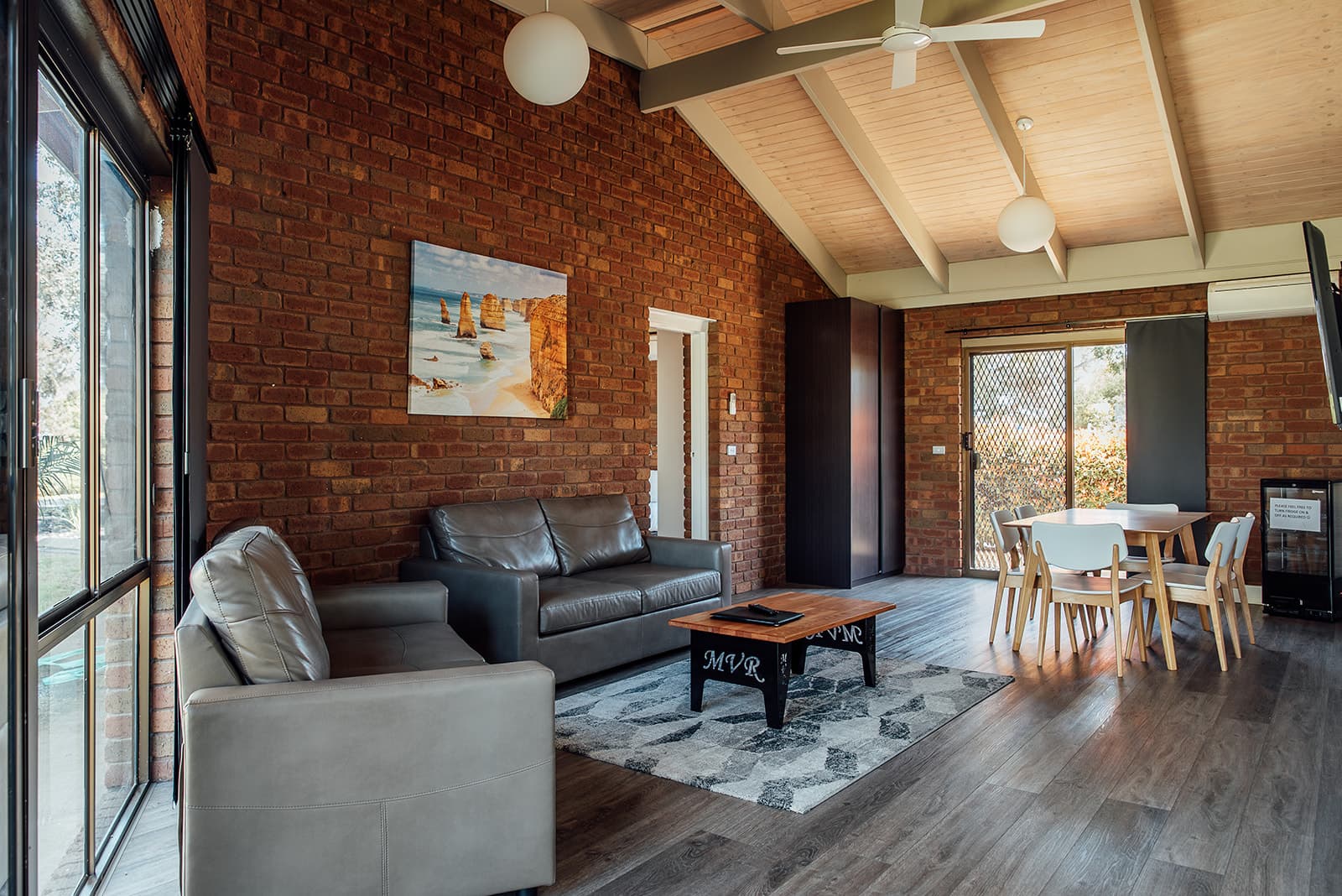 Apartment lounge with a brick feature wall and high ceiling